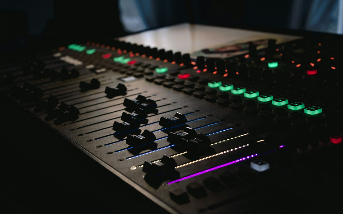 Console de mixage dans un studio sombre, faders éclairés